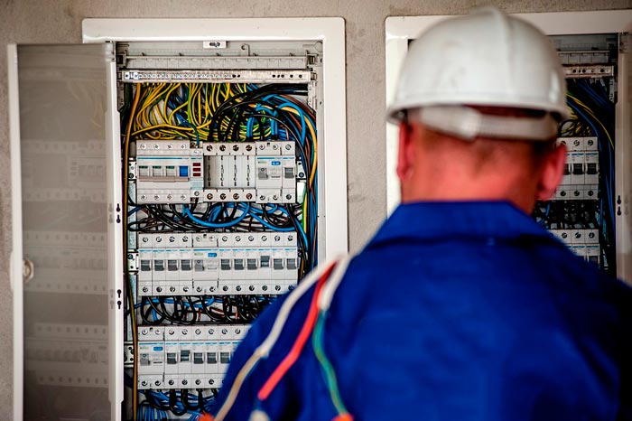 Un electricista mirando un cuadro de electricidad