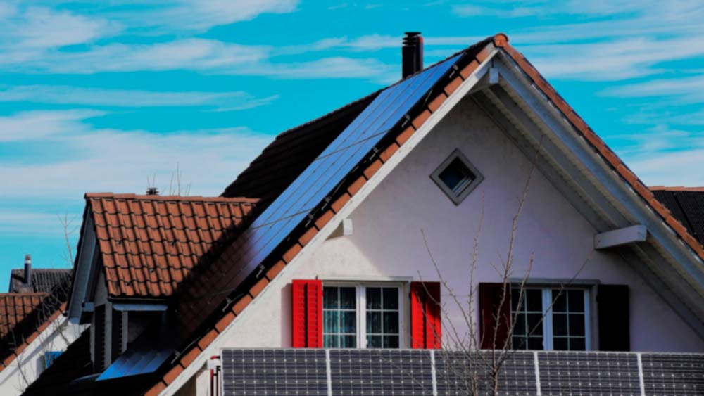 Imagen algo desenfocada de una casa con paneles solares en el techo