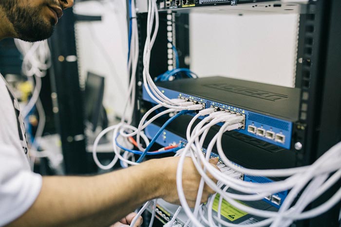 Un trabajador de telecomunicaciones conectando cables